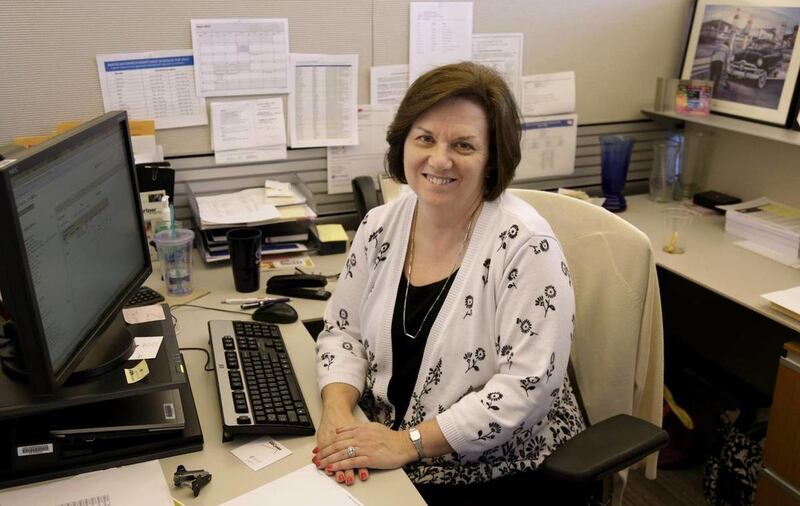 In this June 3, 2013, photo, Nora Kouba, an employee at USG Corporation sits at her work station in Chicago. Over the years, Kouba has made use of a benefit offered by USG that allows their workers to buy and sell vacation time, a perk that gives workers