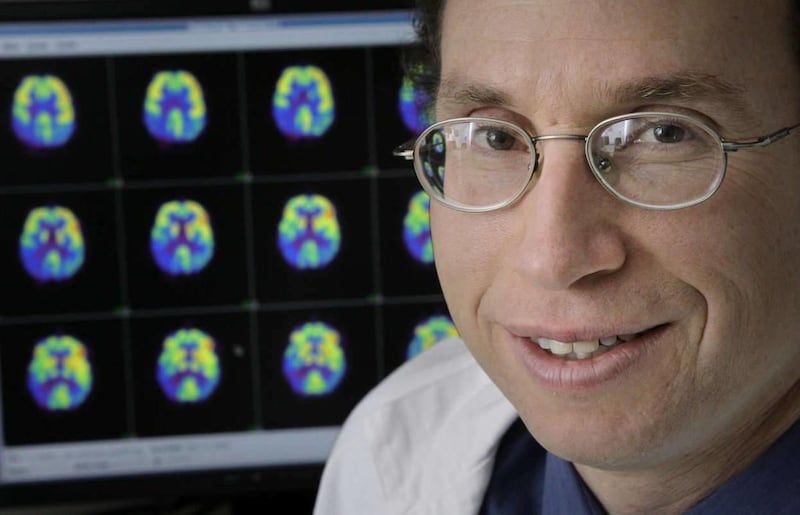 Dr. Andrew Newberg poses with images of brain scans at the Hospital of the University of Pennsylvania in Philadelphia in 2006. He published one of the first studies on meditation and the brain.