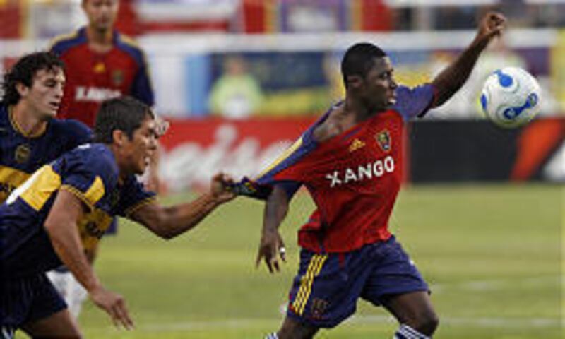 Boca Junior's Jonathan Maidana grabs a fistful of RSL's Freddy Adu during the friendly competition between the teams at Rice-Eccles Stadium.