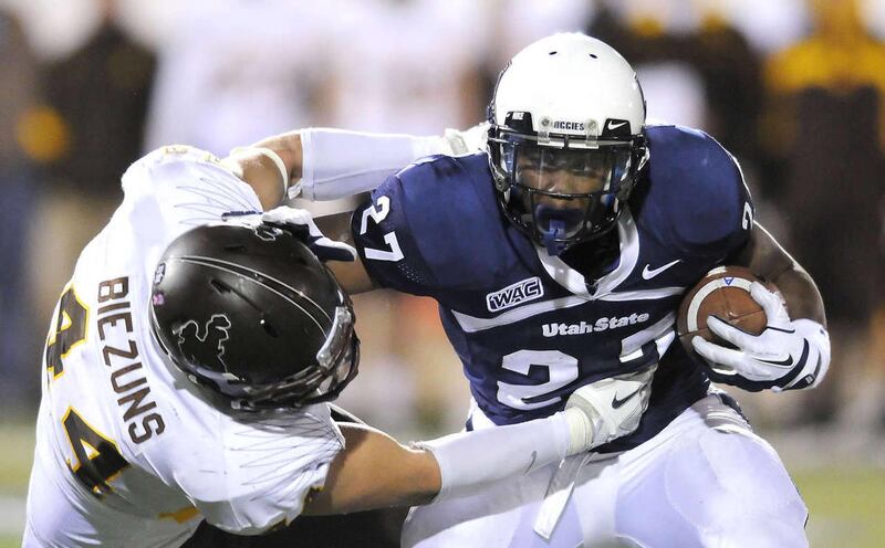 Wyoming defensive end Josh Biezuns (44) tackles Utah State running back Robert Marshall during their NCAA college football game on Saturday, Oct. 8, 2011, in Logan Utah.