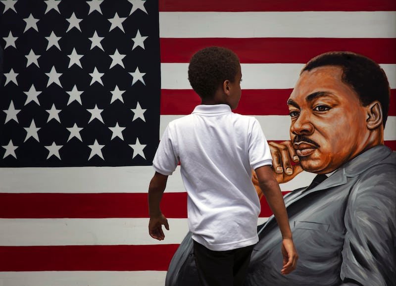 A young boy walks past a painting depicting Dr. Martin Luther King Jr. during a Juneteenth celebration in Los Angeles.