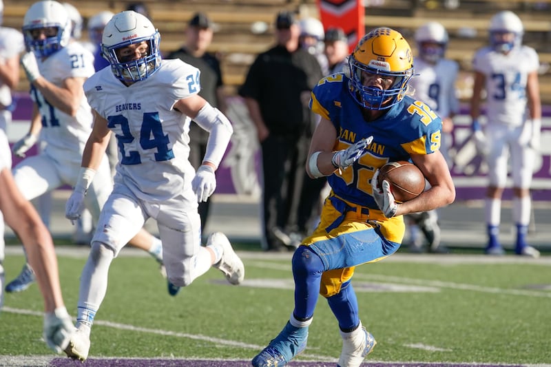 San Juan’s Jensen Grover, wearing blue, runs past Beaver’s defenders as they compete in the 2021 2A football championship game.