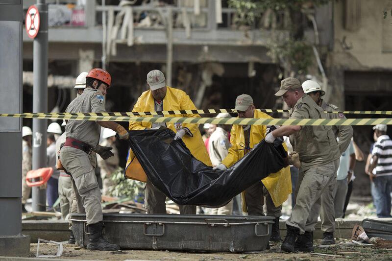 Workers remove a body after an explosion at a restaurant in Rio de Janeiro, Brazil, Thursday Oct. 13, 2011.  Officials say they are investigating the cause of the explosion that killed at least three people and injured at least 13 others.