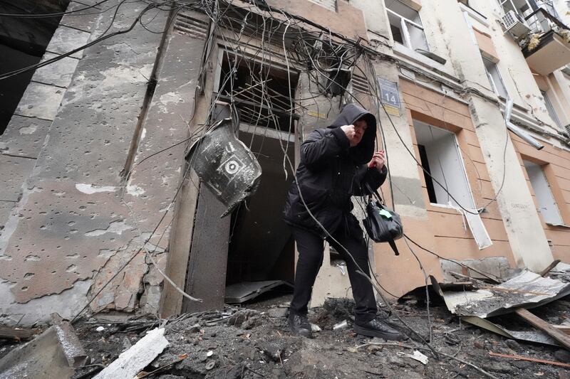 A woman walks out from a residential building which was hit by a Russian rocket, in Kharkiv, Ukraine, Feb. 5, 2023.