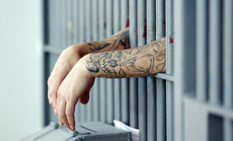An inmate hangs his hands outside the bars at the  Utah State Prison  Wednesday, Feb. 6, 2013.
