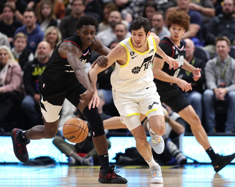 LA Clippers forward Moussa Diabate (25) and Utah Jazz guard Leandro Bolmaro (10) battle for the ball as the lJazz and Clippers play at Vivint Arena in Salt Lake City on Wednesday, Nov. 30, 2022. Utah won 125-112.