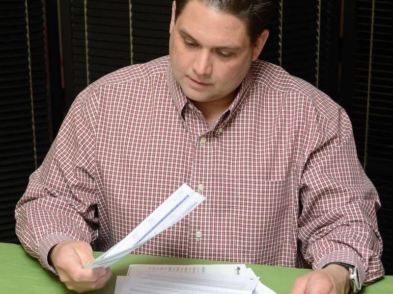 In this March 11, 2011 photo provided by Gina Hacker, Brett Hacker, a photographer for a TV station in Kansas City, Mo., looks over his 401(k) statements. Consumers will soon be able to switch from a 401(k) to a Roth 401(k) if they want due to the America