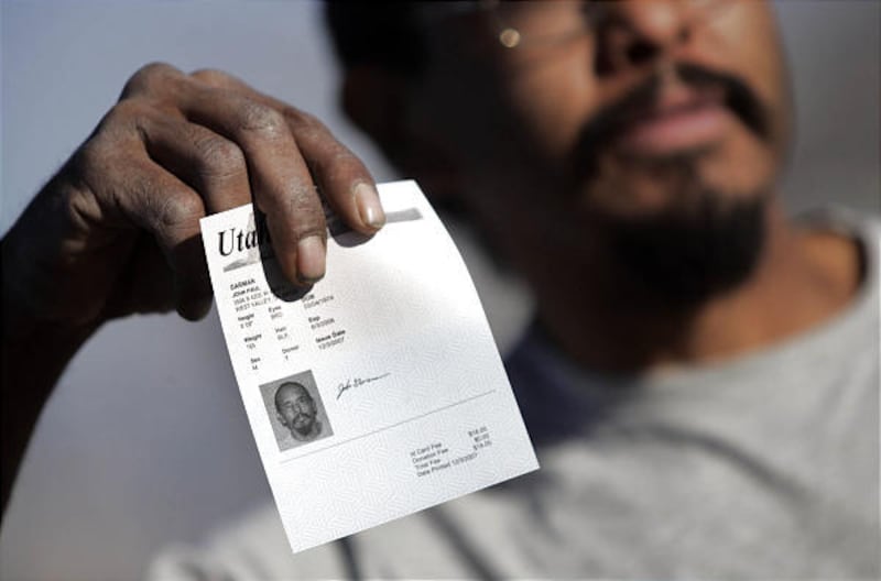 John Garman shows off his temporary Utah identification card at the Driver License Division in West Valley City on Monday.