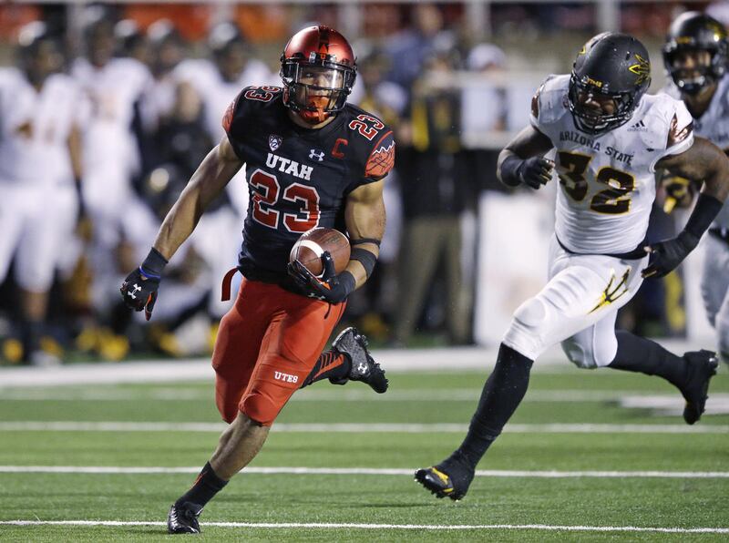 Utah running back Devontae Booker (23) carries the ball for a score as Arizona State linebacker Antonio Longnino (32) pursues during the second half during an NCAA college football game Saturday, Oct. 17, 2015, in Salt Lake City. Utah won 34-18. (AP Photo