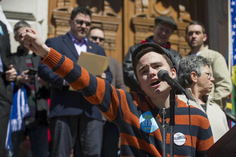 Jackson Blanchard, 18, of Indianapolis, leads the crowd in a chant during the event. Thousands of opponents of Indiana Senate Bill 101, the Religious Freedom Restoration Act, gathered on the lawn of the Indiana State House to rally against that legislatio