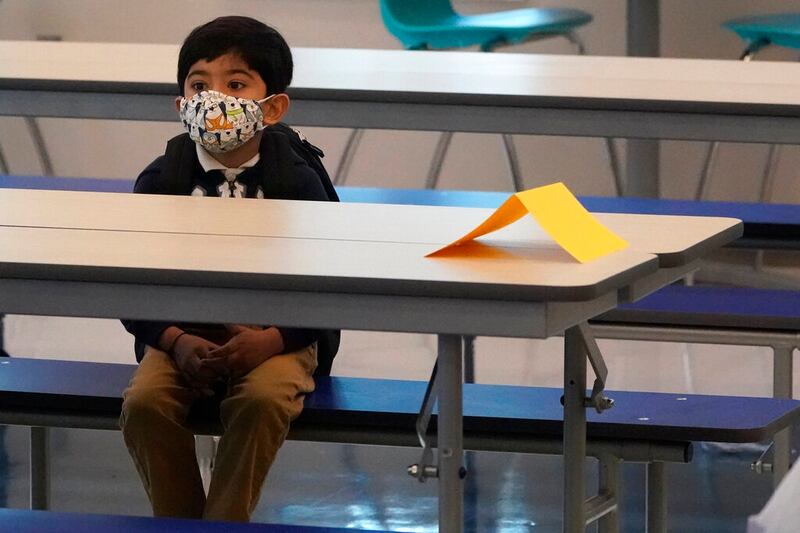 A student waits in the cafeteria the first day of school at Washington Elementary School in Riviera Beach, Florida.