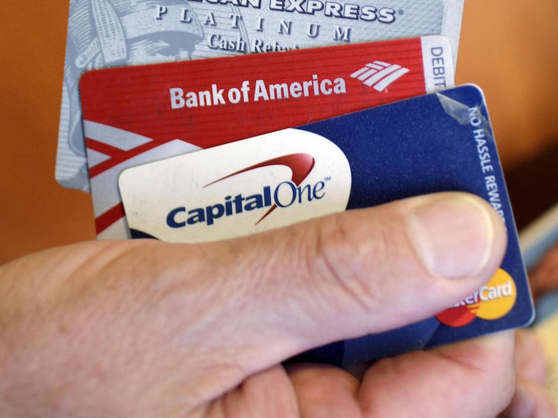 Steve Wheelock holds up his Discover Card along with his American Express, Bank of America and Capital One Visa credit cards in San Francisco, Wednesday, June 22, 2011. Discover Financial Services said Thursday, June 23, its second-quarter profit more tha