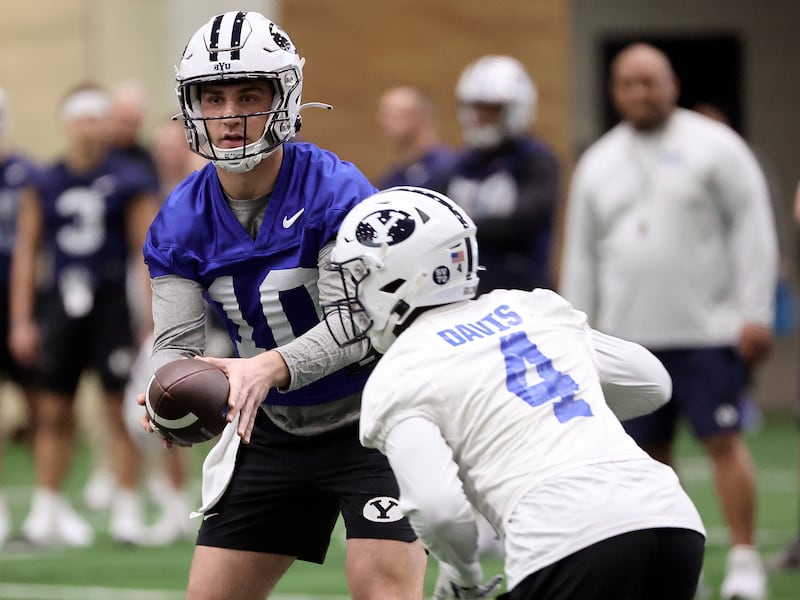 BYU quarterback Kedon Slovis hands the ball off to Miles Davis during opening day of BYU spring football camp at the BYU Indoor Practice Facility in Provo, on Monday, March 6, 2023.