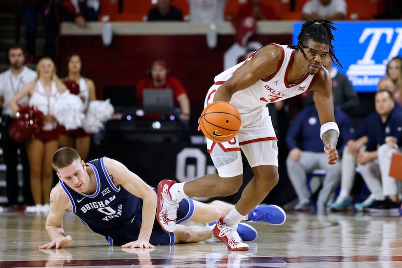 Oklahoma guard Otega Oweh drives the ball away from BYU forward Noah Waterman during the second half of an NCAA college basketball game Tuesday, Feb. 6, 2024, in Norman, Okla.