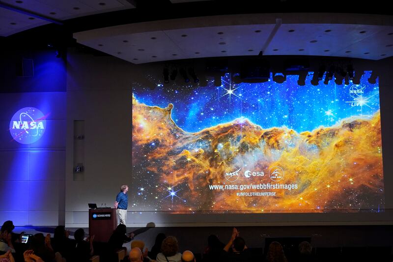 A project scientist for the JWST Mid-Infrared Instrument, speaks in front of an image of the Carina Nebula, captured on the James Webb Space Telescope, during a news conference Tuesday, July 12, 2022, in Pasadena, Calif.