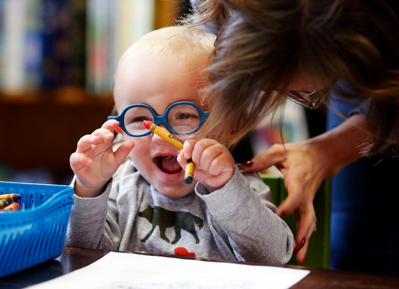 Winston Olch laughs with his mother, Channing, during The History of Magic launch at The King's English Bookshop in Salt Lake City on Friday, Oct. 20, 2017. Some in the Utah community attribute the rise in popularity of young adult fiction over the years
