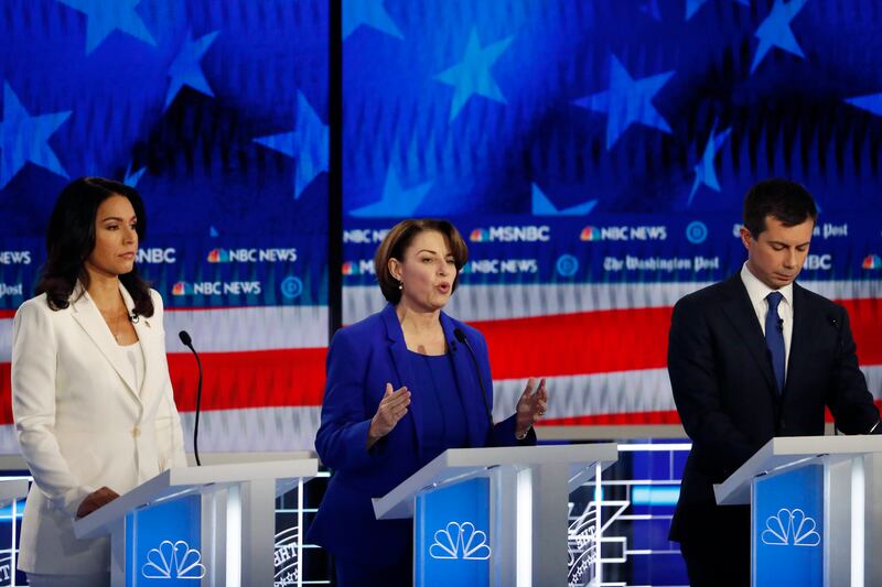Democratic presidential candidate Sen. Amy Klobuchar, D-Minn., center, speaks as South Bend, Ind., Mayor Pete Buttigieg and Rep. Tulsi Gabbard, D-Hawaii, listen during a Democratic presidential primary debate, Wednesday, Nov. 20, 2019, in Atlanta.