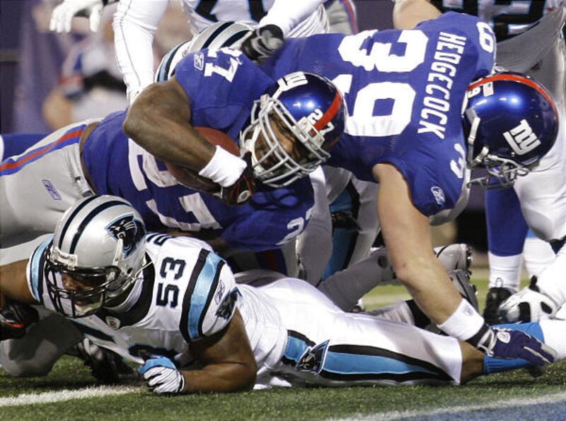 New York Giants running back Brandon Jacobs (27) drives over Panthers linebacker Na'il Diggs to score one of his three TDs.