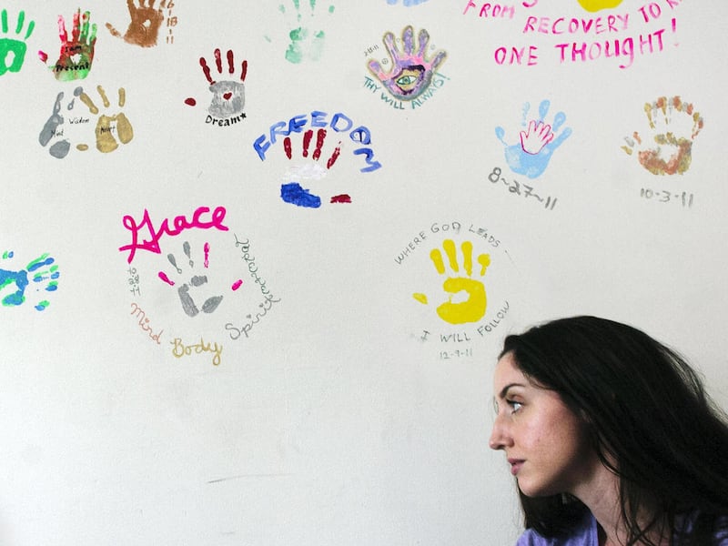 In this March 1, 2012, photo, Kelsey Cusack is pictured in a room at Serenity House in Kenai, Alaska, where she teaches yoga to residents who are trying to overcome addictions. Hand prints on the wall are from graduates of the substance abuse program.
