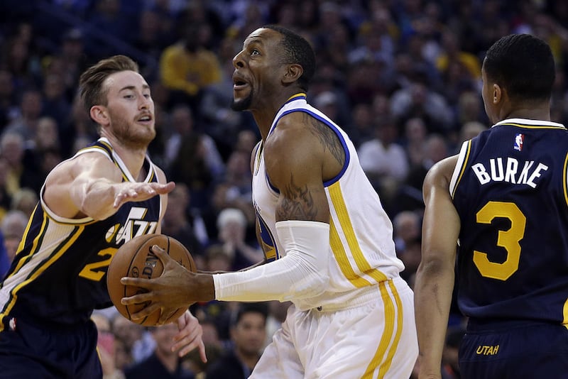 Golden State Warriors' Andre Iguodala, center, drives the ball between Utah Jazz forward Gordon Hayward, left, and Trey Burke (3) during the second half of an NBA basketball game Friday, Nov. 21, 2014, in Oakland, Calif. (AP Photo/Ben Margot)