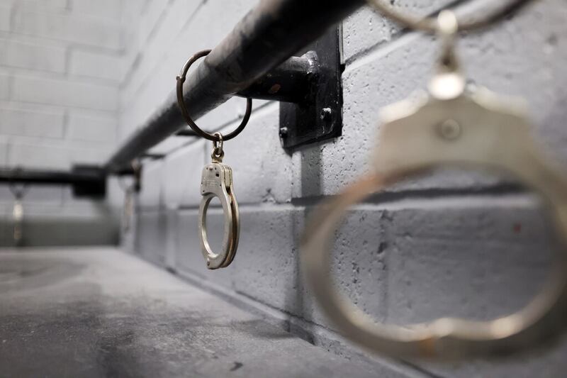 Handcuffs hang from a metal rail in the old Utah State Prison in Draper, Utah.