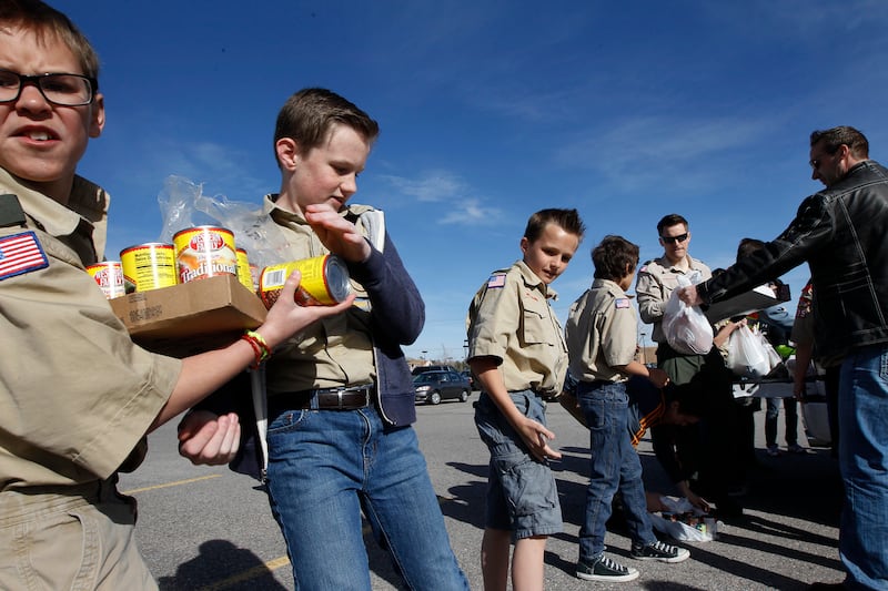 From left, Boy Scouts Luke Beckstrom, Evan Hofheins, Ashton Hofheins and Connor Troxel participate in a food drive assembly line in South Jordan Saturday, March 21, 2015.
