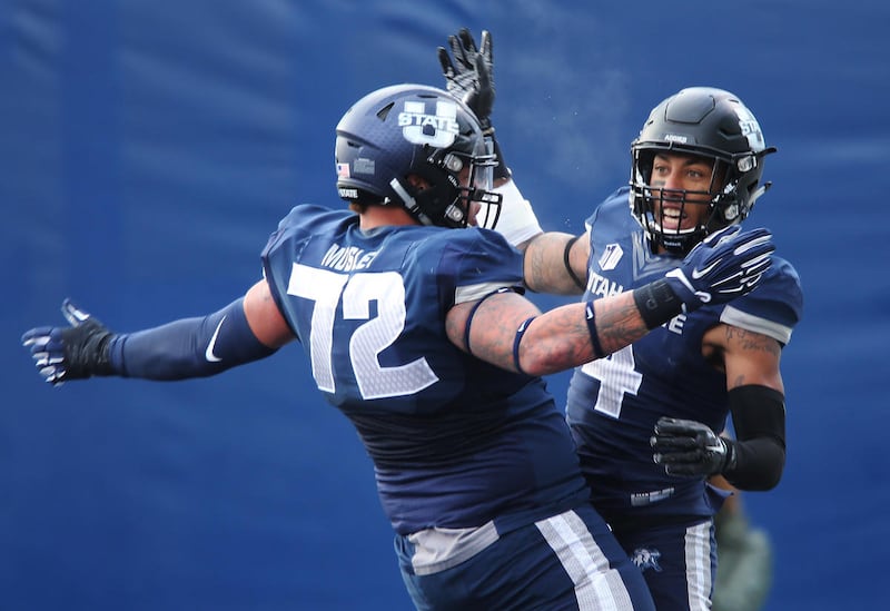 Utah State Aggies wide receiver Hunter Sharp (4) celebrates his touchdown with Utah State Aggies offensive lineman Tyshon Mosley (72) in Logan Saturday, Nov. 28, 2015.