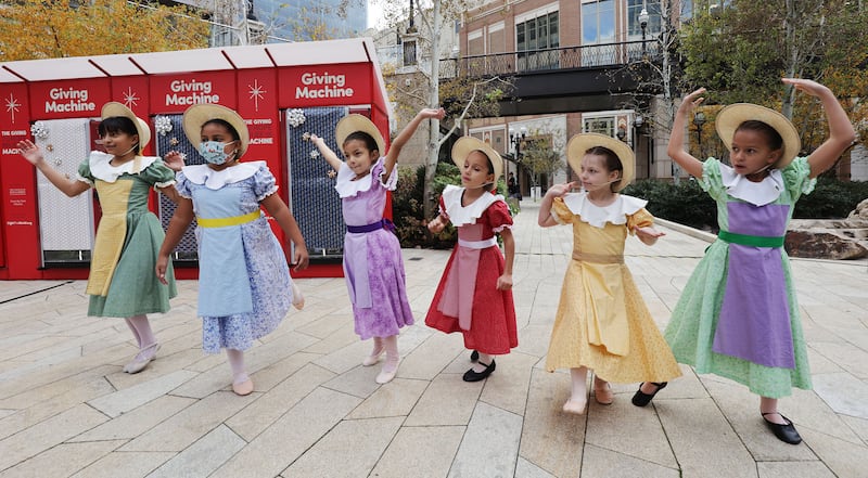 Children with Rise Up School of Dance in colorful dresses perform during the opening of the red Giving Machines.