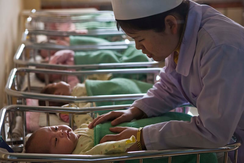 A North Korean nurse comforts a baby at a nursery inside Pyongyang Maternity Hospital in Pyongyang, North Korea.