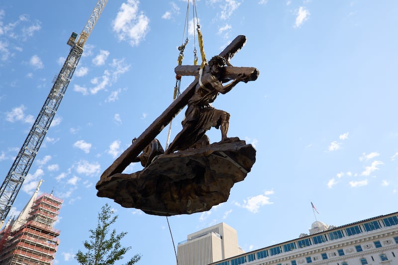 Crew members install the “Jesus Christ Carrying the Cross” statue, created by Michael Hall, just south of the Salt Lake Temple on Wednesday, Sept. 17, 2025.