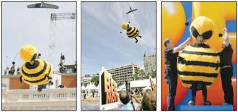 Comedian Jerry Seinfeld created a buzz at the Cannes Film Festival by wearing a bumblebee suit and black tights and flying over the city (with the help of a crane) to promote his "Bee Movie," a DreamWorks Animation film. Atright, wires from his harness ar