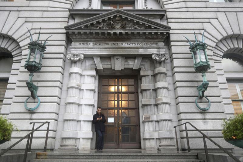 A man stands outside the main door outside the 9th U.S. Circuit Court of Appeals building Thursday, Feb. 9, 2017, in San Francisco. Salt Lake City is among 20 cities and counties across the country who have joined a court brief opposing long and unreviewe