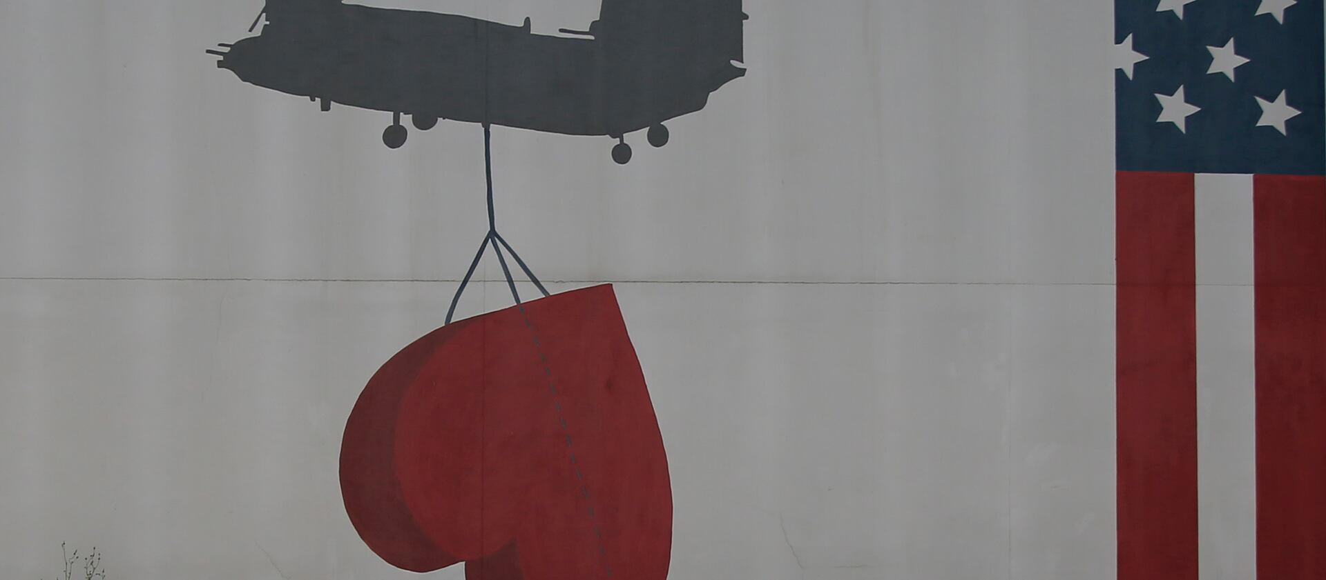 Shadow of a helicopter lifting a heart on the side of the U.S. embassy in Kabul, Afghanistan.
