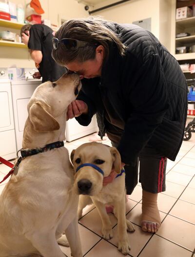 Kathy Conway gets a kiss from Oswald as she pets him and Leno at The INN Between in Salt Lake City on Monday, Dec. 18, 2017.