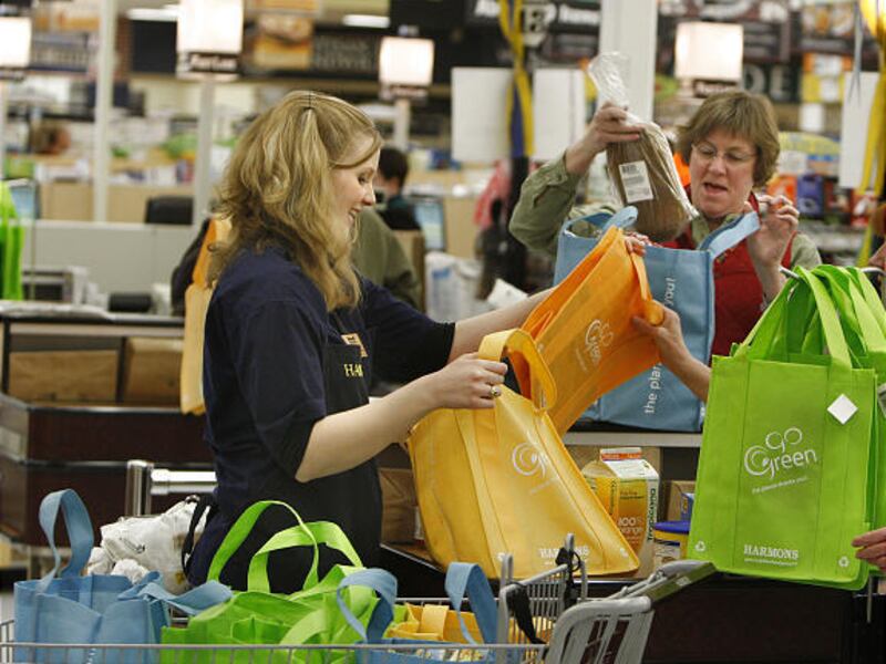 Janice Rampton has her “Go Green” grocery bags filled by Laura Shackelford at Harmons grocery store.