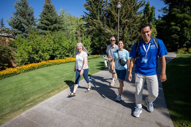 A BYU-Idaho employee, right, leads a new student and her family on a walk-your-schedule tour on Sept. 12, 2025.