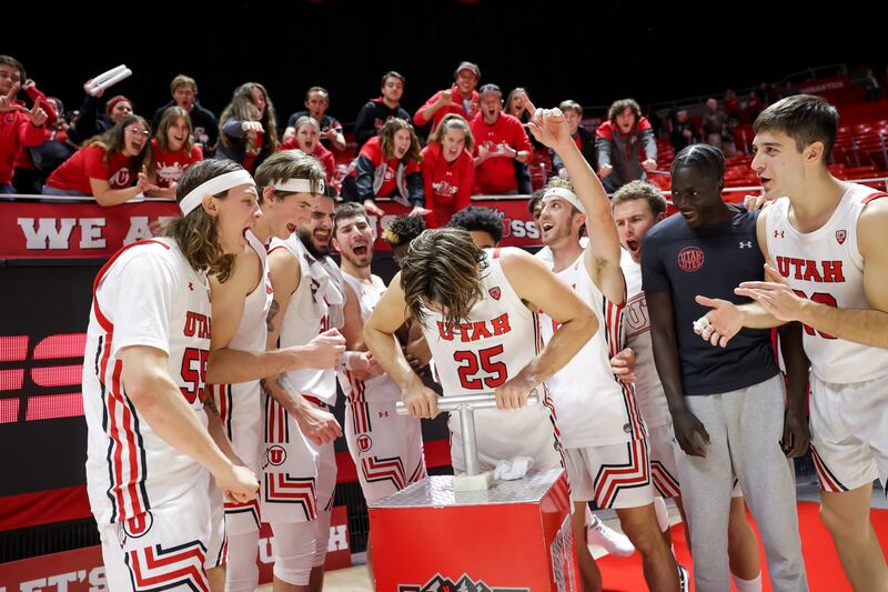 Utah Utes guard Rollie Worster “lights the U” as players and fans cheer.