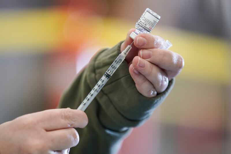 Registered nurse Erin Olpin draws a COVID-19 vaccination dose at a drive-thru clinic.
