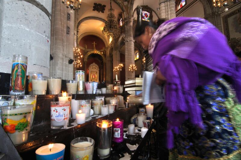 Mexico City, Mexico - December 12, 2012 - A faithful Catholic lights a candle in the old basilica of Guadalupe in veneration of the Virgin on December 12, 2012.