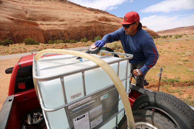 Will Yazzie fills a 250-gallon water tank in Oljato-Monument Valley, San Juan County, on Thursday, April 30, 2020.