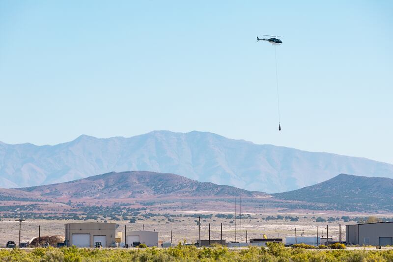 A helicopter long lines the capsule containing a sample collected from the Bennu asteroid as part of NASA’s Osiris-Rex mission from where it was retrieved to a clean room at the U.S. Army’s Dugway Proving Ground in Dugway on Sept. 24, 2023.