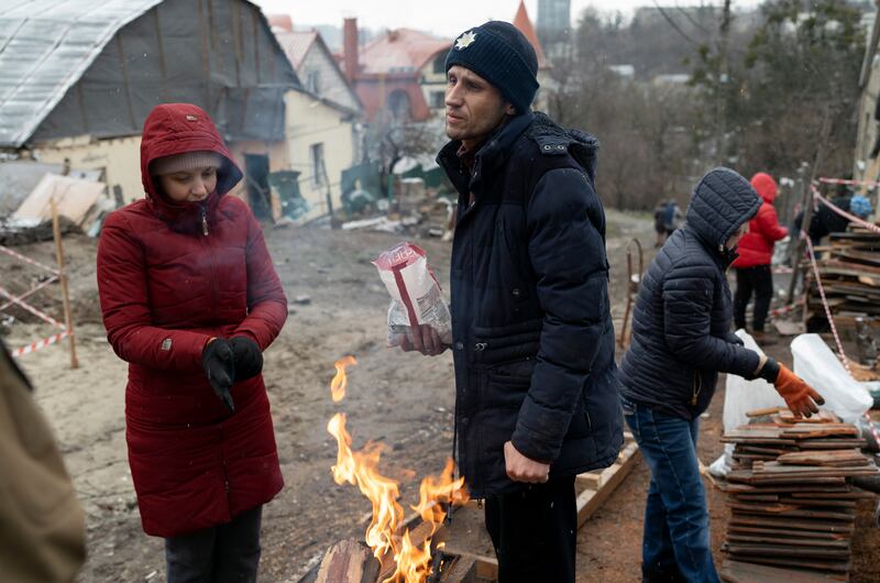 Serhii Kaharlytskiy talks to volunteers helping him to reconstruct his house in Kyiv, Ukraine,