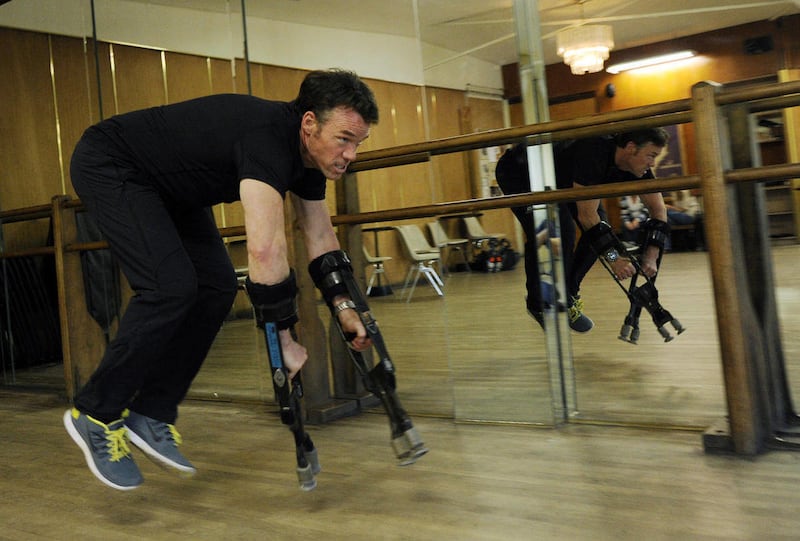 In this Tuesday, June 24, 2014 photo, Terry Notary, a stuntman on the film "Dawn of the Planet of the Apes," demonstrates how he achieved ape-like movements with arm extenders for his motion capture performance for the film, at Hollywood Dance Center in L