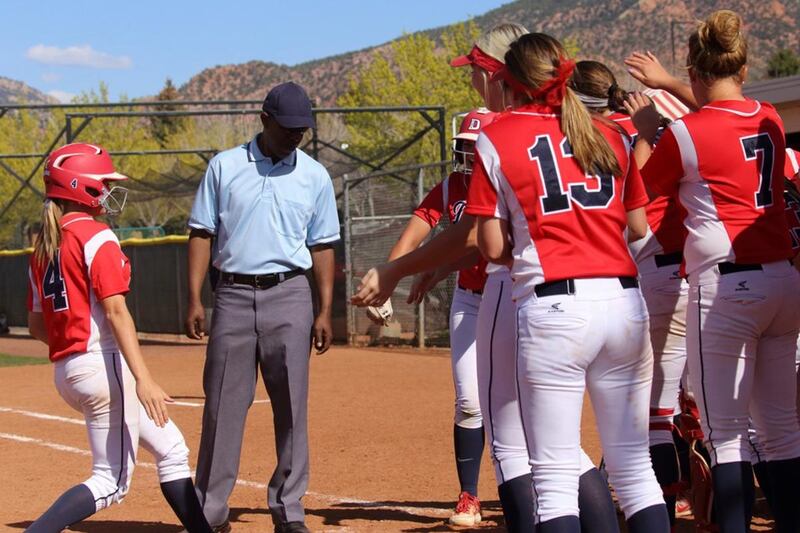 Dixie State freshman Kaitlyn Delange (left) celebrates with her teammates at home plate after hitting her first career home run at SUU on Wednesday.