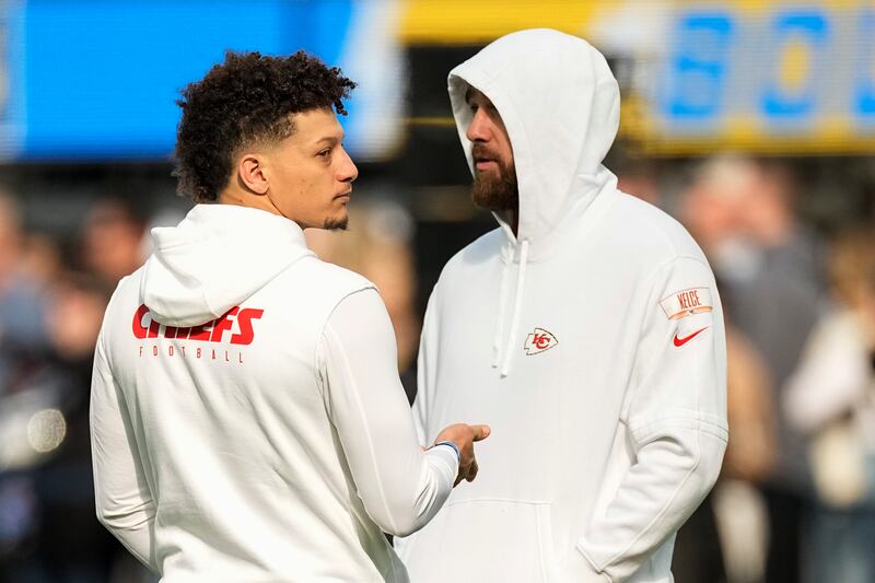 Kansas City Chiefs quarterback Patrick Mahomes, left, talks with tight end Travis Kelce before an NFL football game against the Los Angeles Chargers, Sunday, Jan. 7, 2024.