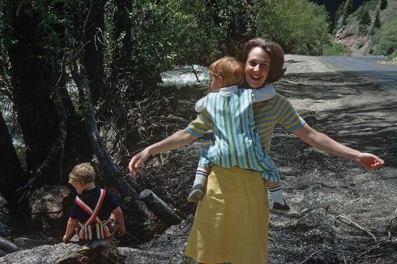 Sister Kathleen Johnson Eyring smiles as son Stuart hangs on her neck on his first birthday while Henry J., plays nearby.