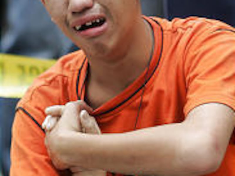 Melvin Salazar cries as he holds the hand of his dead mother, who was crushed in a stampede to enter a stadium in Manila.