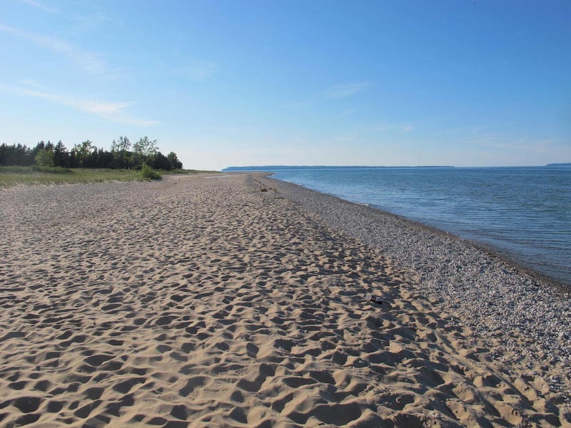 In this photo taken Wednesday, June 29, 2011, a lengthy stretch of sandy Lake Michigan beach is deserted on a sunny afternoon at Sleeping Bear Dunes National Lakeshore. Partly because of the absence of big crowds, Sleeping Bear was the winner in the init