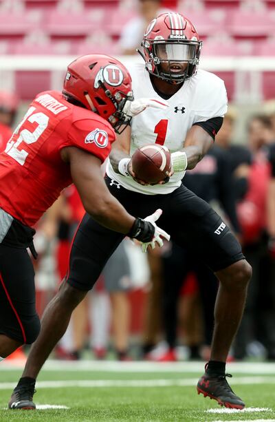 Utah QB Tyler Huntley hands the ball to Devin Brumfield during a scrimmage at Rice-Eccles Stadium in Salt Lake City on Friday, April 5, 2019.