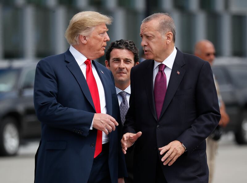 President Donald Trump, left, talks with Turkey’s President Recep Tayyip Erdogan, as they arrive together for a family photo at a summit of heads of state and government at NATO headquarters in Brussels.